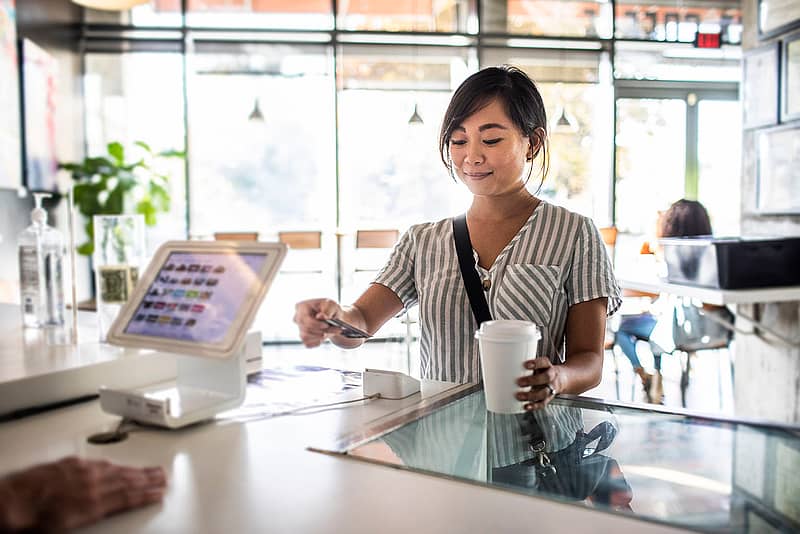 Depiction of person paying for coffee with bank account.